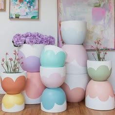 there are many vases with flowers in them sitting on the floor next to each other