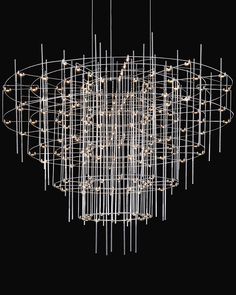 a large chandelier with lights hanging from it's center and circular metal rods