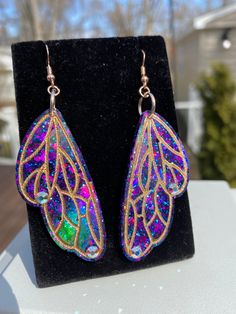 These gorgeous one of a kind moth/fairy wing earrings are handmade with resin and are very lightweight. They colorshift to deep bejeweled purple, pink, and blue hues and are holographic. They will sure make a statement on your ears 💖 Handmade by Katie  KG Design & Decor Please follow my on social media  Instagram: @KG_DesignandDecor Facebook: KG Design and Decor Please be aware that this is handmade art and perfection has no place in art.  However, this was crafted with love and intention and I Iridescent Butterfly-shaped Handmade Jewelry, Iridescent Fairy Jewelry For Parties, Iridescent Fairy-style Jewelry For Parties, Iridescent Fairy Style Jewelry For Party, Handmade Iridescent Jewelry In Butterfly Shape, Handmade Iridescent Butterfly Jewelry, Multicolor Fairy Style Jewelry Gift, Fairy Style Multicolor Jewelry Gift, Fairy Style Multicolor Jewelry For Gifts