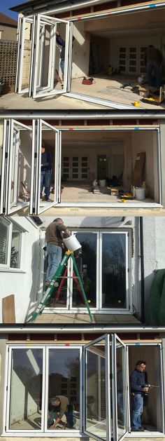 two men are working on the side of a building that is being built with windows