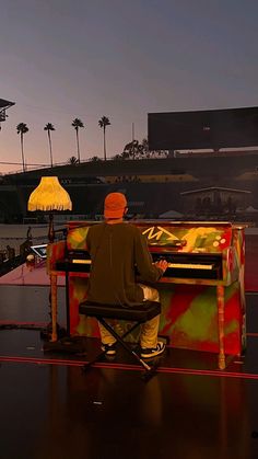 a man sitting at a piano on top of a stage