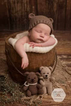 a baby sleeping in a bucket with two teddy bears