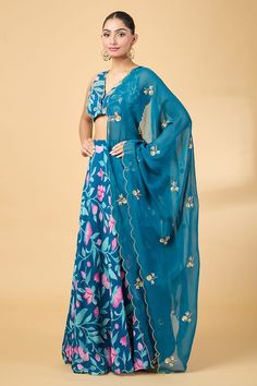 Teal blue scallop bordered blouse with floral print and aari, zardosi embroidery. Paired with coordinating lehenga and scallop hem dupatta. - Aza Fashions Blue Palazzo Set With Unstitched Blouse For Reception, Blue V-neck Blouse Piece For Wedding, Blue V-neck Blouse For Wedding, Blue V-neck Navratri Sets, Blue Sleeveless Sets With Floral Embroidery, Blue Floral Print Anarkali Set For Wedding, Blue Floral Print Dupatta For Navratri, Blue V-neck Bollywood Style Sets, Festive Blue Floral Print Blouse Piece