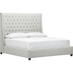 an upholstered bed with white linens and buttons