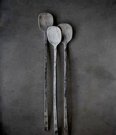 three spoons are placed next to each other on a black surface with dark background