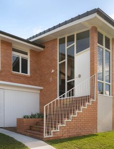 a brick house with a white door and stairs