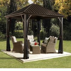 a gazebo sitting on top of a lush green field next to a lawn covered in furniture