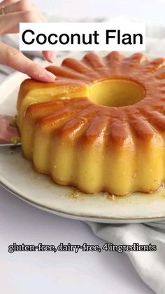 a person placing a piece of cake on top of a plate with the word coconut flan above it