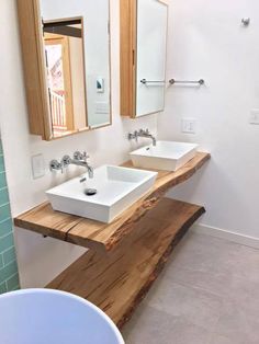 a bathroom with two sinks and wooden counter tops