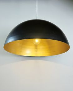 a black and gold lamp hanging from a ceiling