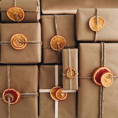 wrapped presents with orange slices and ribbons tied in twine on top of each other