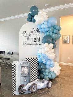 a balloon arch is decorated with blue and white balloons in the shape of a race car