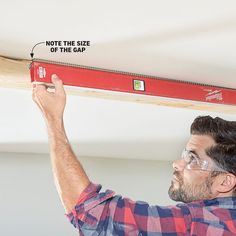 a man is measuring the width of a beam with a tape measure ruler on it