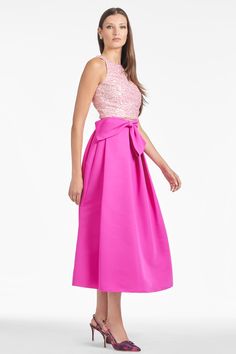 The Whitley skirt in cerise is the dream day-to-night, all-year-long skirt. This perennial silhouette is made more special with our signature pop of pink. At the waist a faux full bow-belt sash with stitched down belt both flatters and conceals. A side zip closure allows for a clean finish to this spectacular skirt. Details:Model is 5'10" wearing a size 2Full Length 52"35 1/2" Skirt Length100% PolyesterSide ZipperImportedStyle #F241S01-670 Elegant Pink Prom Skirt, Elegant Pink Evening Skirt, Pink Midi Skirt For Evening, Pink Satin Skirt For Party, Pink Evening Skirt, Pink Satin Party Skirt, Chic Pink Skirt For Cocktail, Chic Pink Dress With Flared Skirt, Pink Party Dress With Midi Skirt