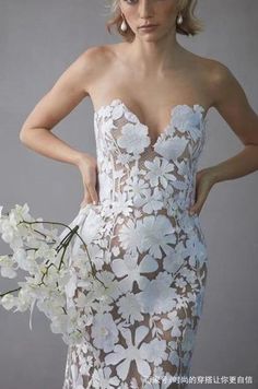 a woman in a white dress holding a bouquet of flowers