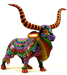 a colorful bull statue with long horns on it's head and tail, standing in front of a white background