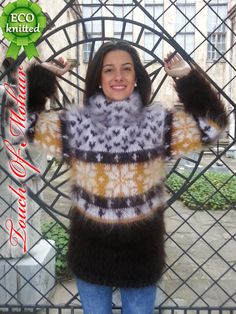 a woman standing in front of a fence with her hands up to the ceiling and wearing an animal - print sweater