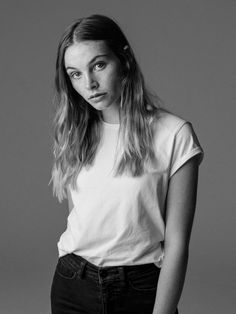 a black and white photo of a woman with long hair wearing a t - shirt