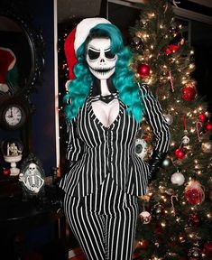 a woman dressed as a skeleton standing in front of a christmas tree with green hair