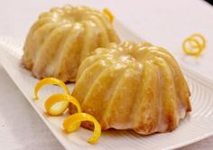 two bundt cakes sitting on top of a white plate next to orange peels