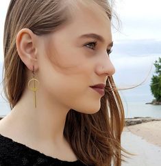 Simple and understated, these modern minimalist earrings are a great go to for everyday wear, to work or a night out. The earrings feature a long golden brass bar that is chin grazing through the middle of a brass geometric circle.  These lightweight earrings hang about 2.75 inches in length while the circle hangs 1.5 inches length. The entire look is topped off with a nickel and lead free french ear wire.For more earrings check out our selection here: https://www.etsy.com/shop/DyNaModuo?section Gold Minimalist Earrings, Drop Earrings Simple, Minimalist Earrings Gold, Brass Bar, Gold Bar Earrings, Jewelry Simple, Geometric Circle, Earrings Geometric, Lightweight Earrings