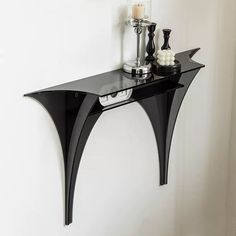 a black shelf with two candles on it