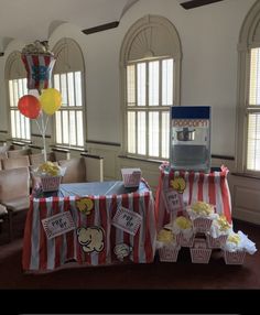 two tables with popcorn and balloons on them