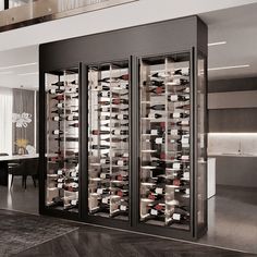 the wine cellar has many bottles of wine in its glass doors, and is open to let people know what's inside