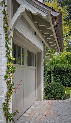 a white garage with an attached awning over the door and side entrance to it