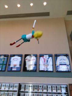 an assortment of baseball memorabilia hanging from the ceiling in front of a wall with pictures on it