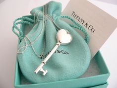 Offered for sale is a gorgeous Tiffany & Co. Sterling Silver Heart Key locket necklace. Hanging from its gorgeous Tiffany silver chain is a very pretty heart locket in the shape of a key - super cool piece! Perfect piece to store one or two pictures or keepsakes, and always keep them close to your heart! The necklace is a wonderful piece that is simple, elegant, and classic all rolled into one. It works perfectly with pretty much any attire your put on, AND adds a nice feminine touch to it. It i Key Locket Necklace, Key Locket, Interlocking Circle Necklace, Silver Link Necklace, Pretty Heart, Pretty Jewelry Necklaces, Tiffany Necklace, Heart Key, Charm Chain