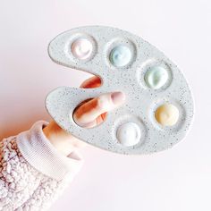 a person holding an egg tray with six eggs in it's middle and two fingers on the other side