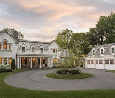 a large white house sitting on top of a lush green field