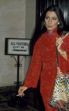 a woman in a red dress carrying shopping bags