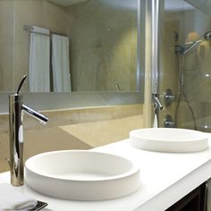 two white bowls are on the counter in this bathroom