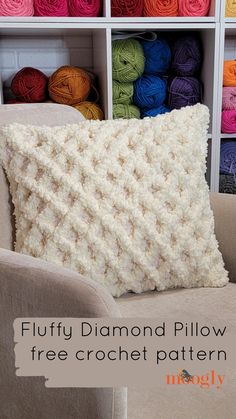 a crocheted pillow sitting on top of a chair next to a shelf filled with yarn