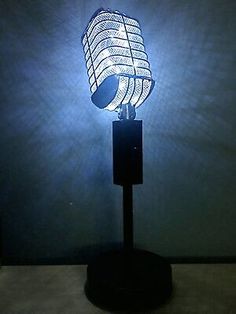 a lamp that is sitting on top of a wooden stand with a light in the shape of a microphone