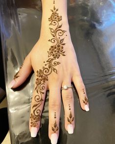 a woman's hand with henna tattoos on it