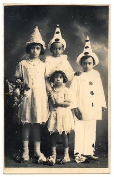 an old black and white photo of three children wearing party hats, standing next to each other