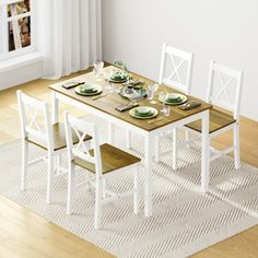 a dining room table set with white chairs and place settings on the wooden floor in front of a window