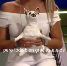 a woman holding a small white dog in her arms with the caption'perro too bien gracias a dios '