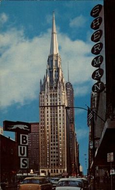 cars are driving down the street in front of tall buildings with spires on top