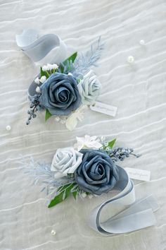 two blue and white boutions are on a bed with ribbons in the shape of letters