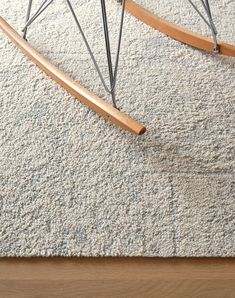 a close up of a rug on the floor with a chair in front of it