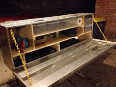 a metal bench with plastic bins on it and yellow chains hanging from the back