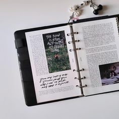 an open book with pictures and writing on the pages is laying next to a keychain