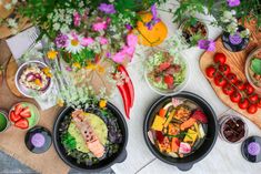 a table topped with plates of food and bowls of salads on top of it