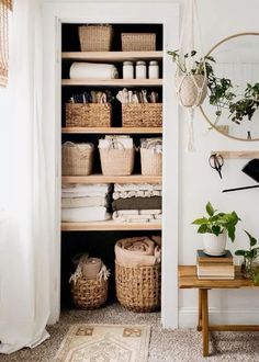 an organized closet with baskets, towels and other household items in it's shelves