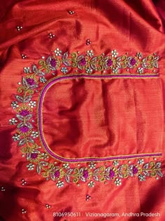 an embroidered red jacket with flowers and beads on it