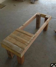 a wooden bench made out of pallets in a garage with other pieces of wood